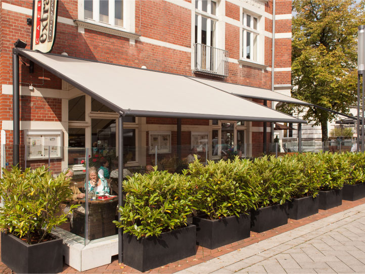 Image of syncra system fitted with pergolas to cover seating area outside cafe.